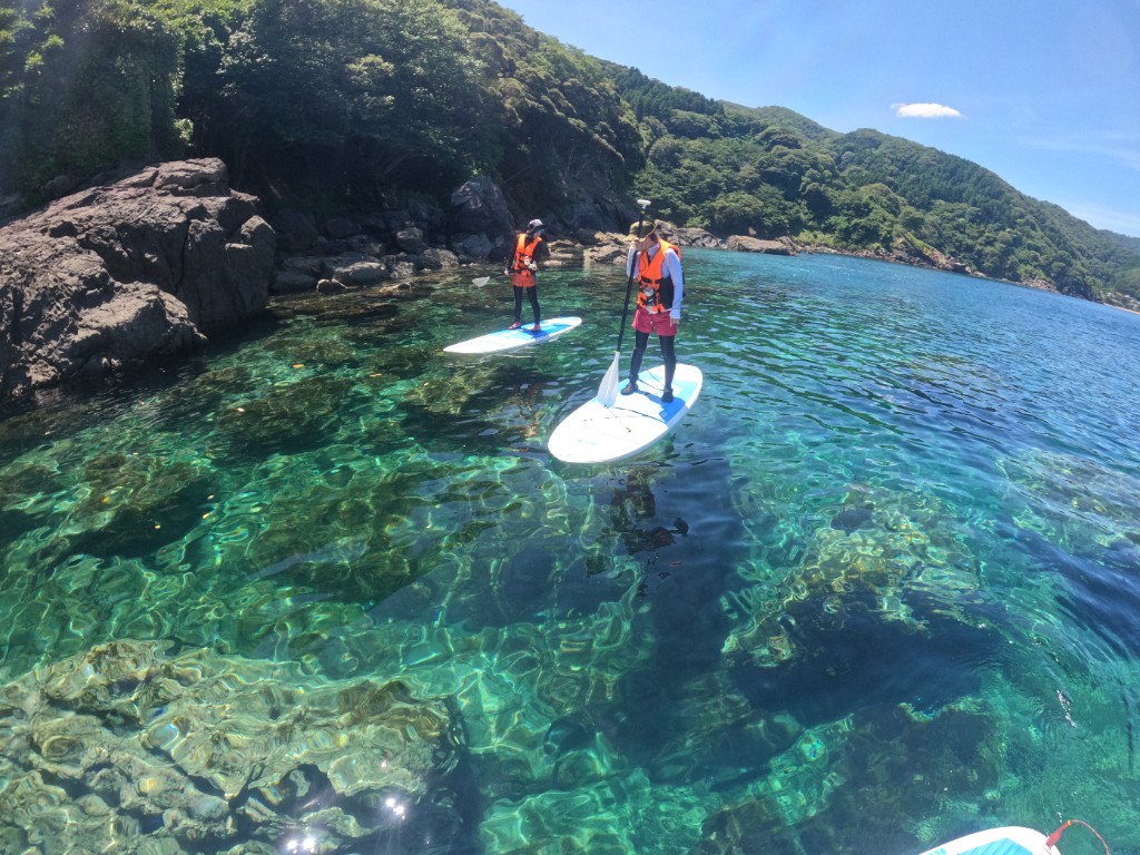 透明度の高い海をSUPで進む二人