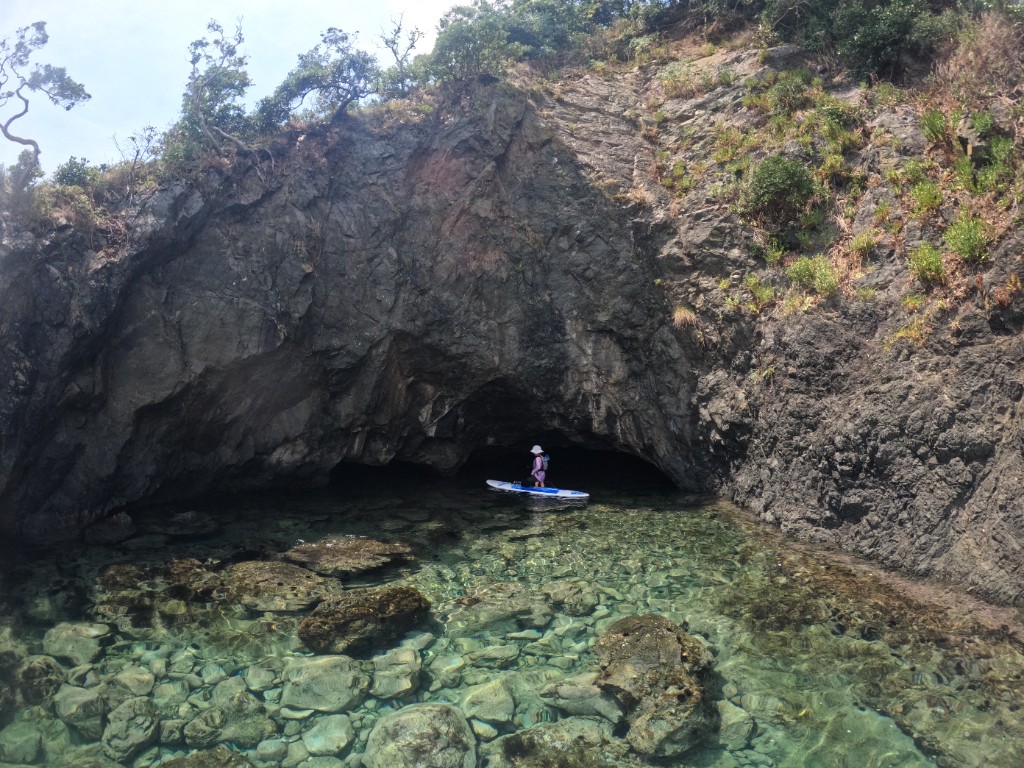 岩場の浅瀬をSUPで進む二人